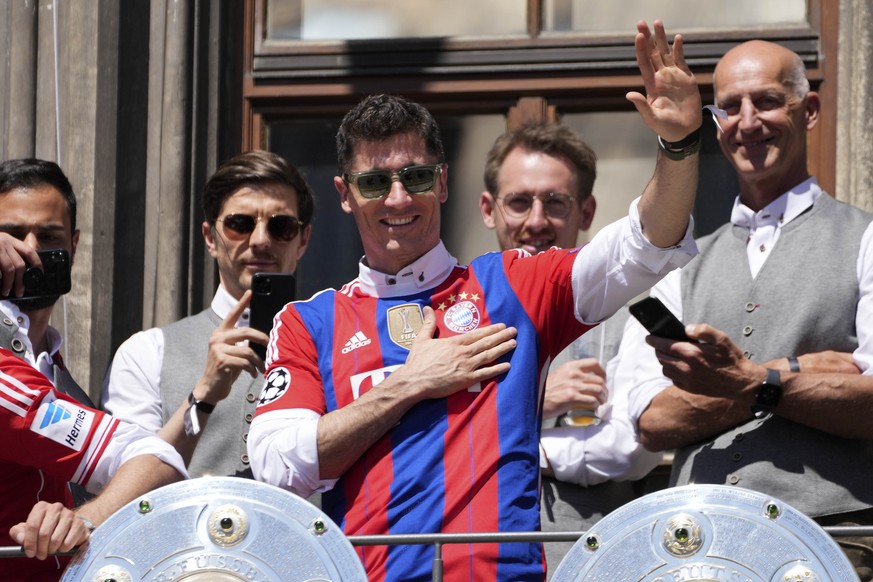 Bayern's Robert Lewandowski gestures to supporters as he stands on the balcony of the town hall at Marienplatz square celebrating the 31th Bundesliga title at the German Bundesliga in Munich, Germany, ...
