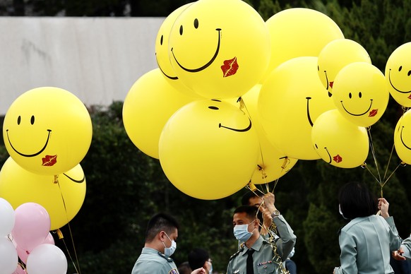 epa08784993 Military officers carry smiley balloons during a military mass wedding in Taoyuan, Taiwan, 30 October 2020. Two same sex couples tied the knot as part of a mass wedding held by the Taiwan  ...