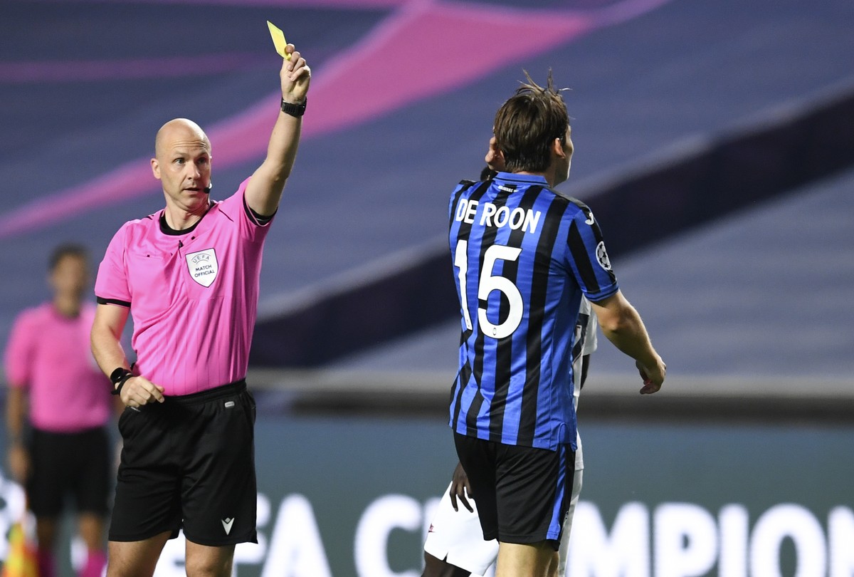 Referee Anthony Taylor shows a yellow card to Atalanta's Marten de Roon, right, during the Champions League quarterfinal match between Atalanta and PSG at Luz stadium, Lisbon, Portugal, Wednesday ...