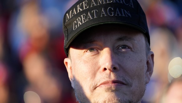 FILE - Tesla and SpaceX CEO Elon Musk listens as Republican presidential nominee former President Donald Trump speaks at a campaign event at the Butler Farm Show, Oct. 5, 2024, in Butler, Pa. (AP Phot ...