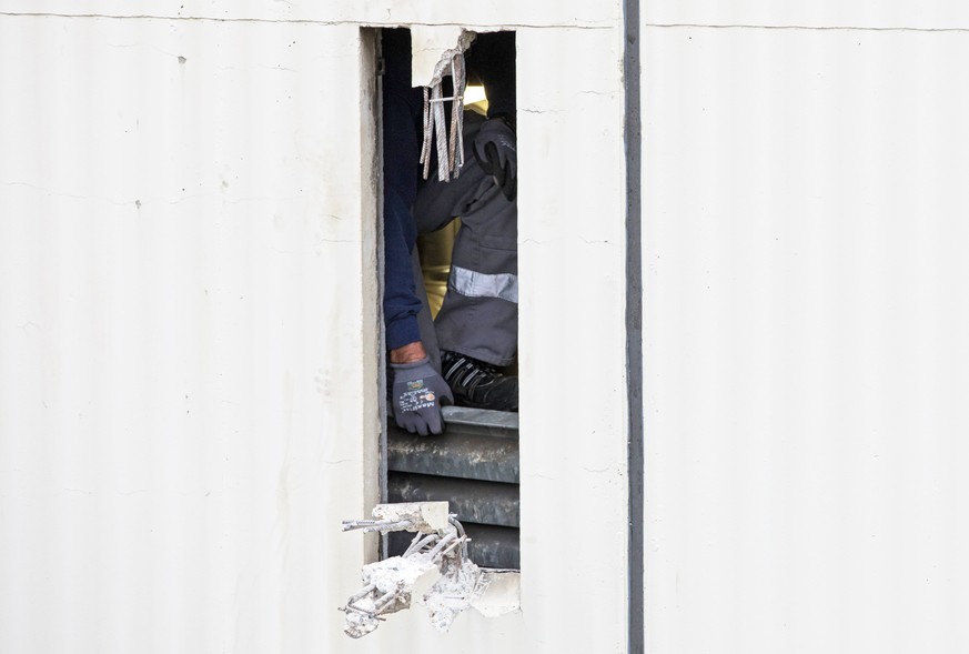 epa06407896 A craftsman fixes a metal plate behind a hole to close it in the wall of Ploetzensee prison in Berlin, Germany, 28 December 2017. Four inmates of the prison escaped through a hole in the w ...