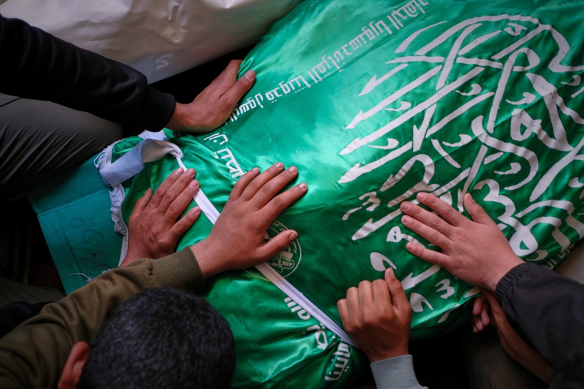 KEYPIX - Palestinians place their hands on the body of Izz al-Din al-Haddad, the leader of Hamas' Qassam Brigades, draped in a Hamas flag during his funeral in Gaza City, Saturday, May 16, 2026.  ...