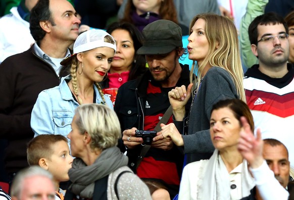 PORTO ALEGRE, BRAZIL - JUNE 30: Lena Gercke (L), girlfriend of Sami Khedira of Germany, and Sarah Brandner, girlfriend of Bastian Schweinsteiger of Germany, (R) look on during the 2014 FIFA World Cup  ...