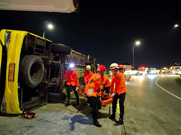 251222 -- SEMARANG, Dec. 22, 2025 -- This photo provided by Indonesia s National Search And Rescue Agency Semarang region shows rescuers transferring an injured passenger after a bus crash in Semarang ...