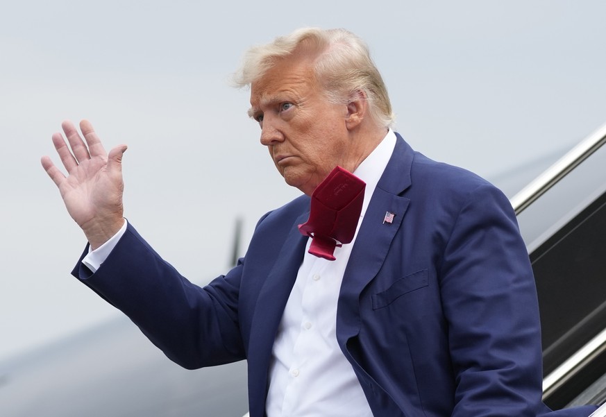 FILE - Former President Donald Trump waves as he steps off his plane at Ronald Reagan Washington National Airport, Aug. 3, 2023, in Arlington, Va. A slim majority of Americans approve of the U.S. Just ...