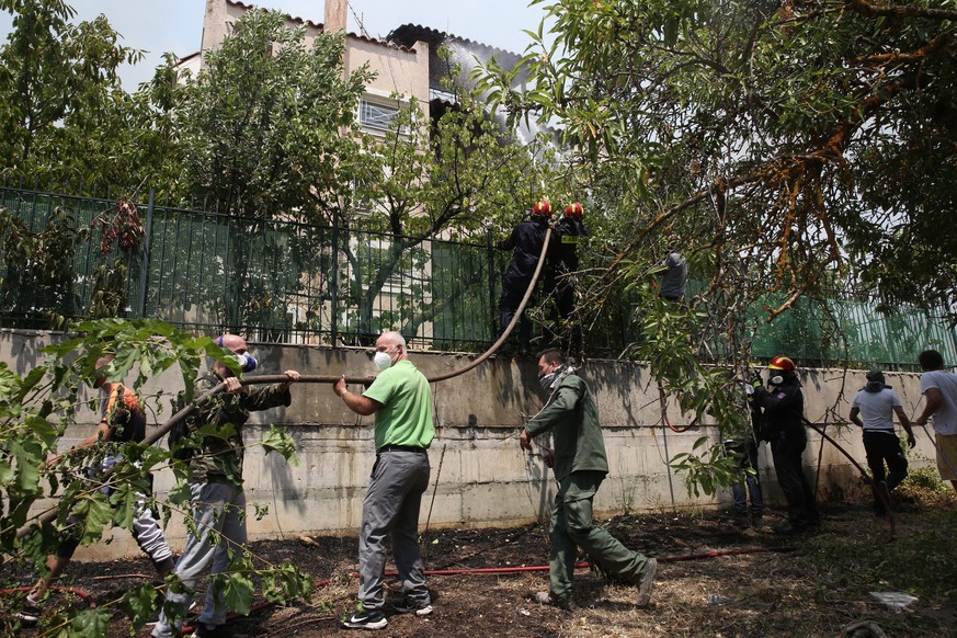 epa09400327 Citizens and volunteers firefighters battle to extinguish a wildfire burning in Kryoneri area, near Athens, Greece, 06 August 2021. The fires in Attica continued to blaze uncontrollably on ...