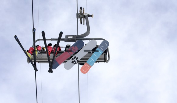 epa06513486 Athletes (R) are accompanied by Olympic volunteers (L) on a ski lift during the Men&#039;s Snowboard Slopestyle competition at the Bokwang Phoenix Park during the PyeongChang 2018 Olympic  ...