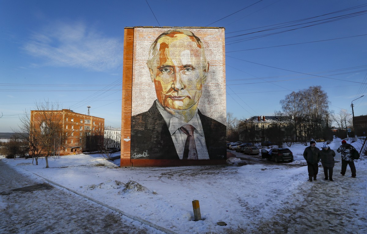 epa10401645 People walk past a large mural depicting Russian President Vladimir Putin, on the side of a five-story residential building in Kashira, Moscow region, Russia, 12 January 2023. The years-ol ...