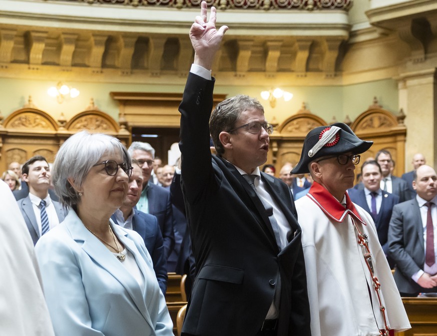 The new Federal Councillors Albert Roesti, center, and Elisabeth Baume-Schneider, left, are sworn in following the election of replacements to the Federal Council by the United Federal Assembly in Ber ...