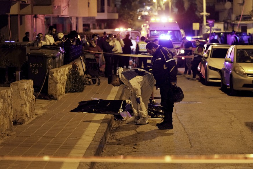 Israeli police examine the body of a shooting victim in Bnei Brak, Israel, Tuesday, March 29, 2022. The circumstance of the deadly incident in the city east of Tel Aviv were not immediately clear. (AP ...
