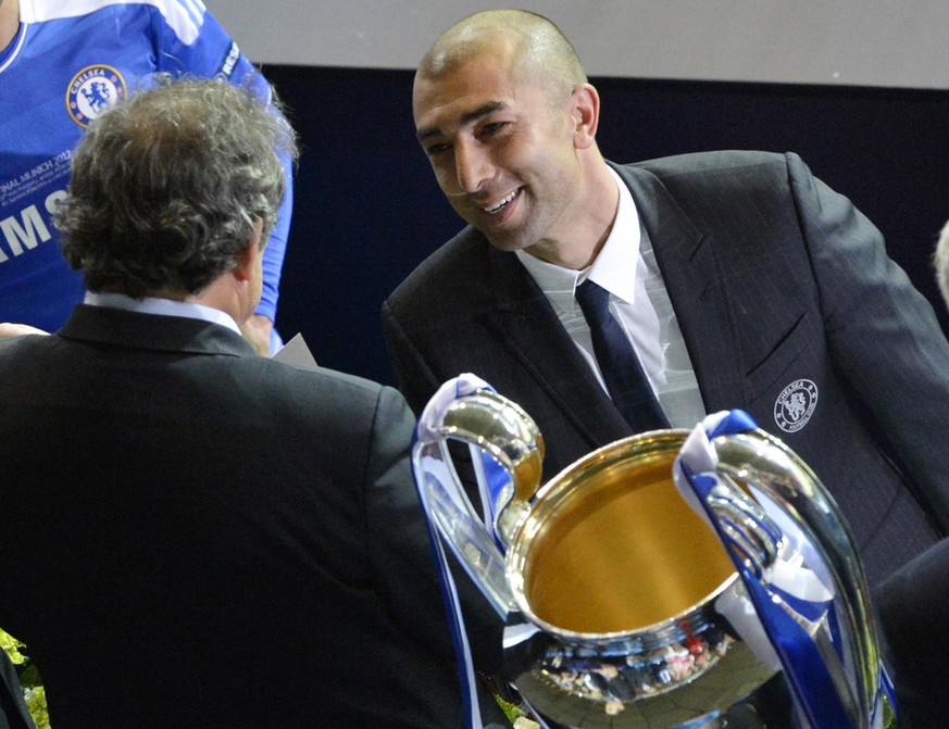 Chelsea coach Roberto Di Matteo, right, looks at UEFA president Michel Platini as he holds the trophy at the end of the Champions League final soccer match between Bayern Munich and Chelsea in Munich, ...
