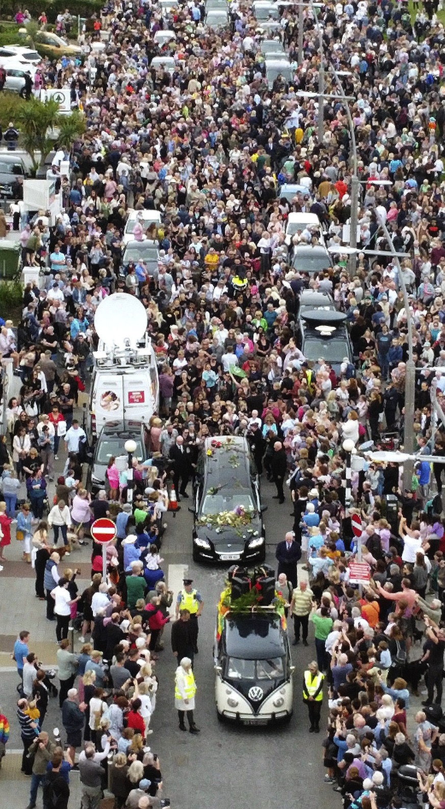 Fans of singer Sinead O&#039;Connor line the streets as her funeral cortege passes through her former hometown of Bray, Co Wicklow, Ireland, Tuesday, Aug. 8, 2023. O?Connor?s family invited the public ...