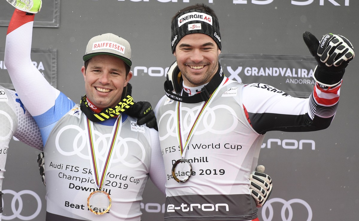 epa07433700 Downhill World Cup winner Beat Feuz (C) of Switzerland, second placed Italy's Dominik Paris (L) and third placed Austria's Vincent Kriechmayr (R) pose on the podium after the Men ...