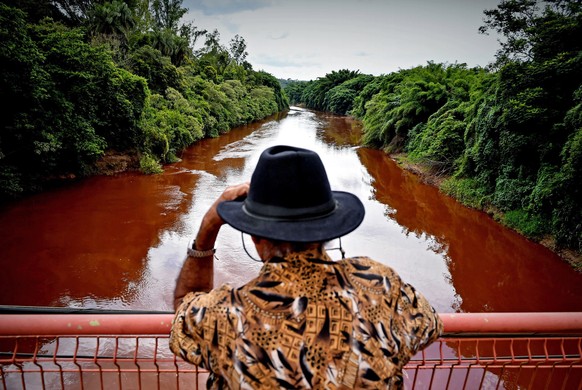 epa07322277 A man watches the Paraopeba River with mud and waste from the disaster caused by dam spill in Brumadinho, Minas Gerais, Brazil, 26 January 2019. At least nine people have died and 300 are  ...