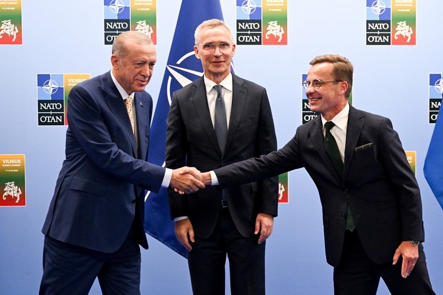 epaselect epa10737921 Turkish President Recep Tayyip Erdogan (L) shakes hands with Swedish Prime Minister Ulf Kristersson (R) as the Secretary General of NATO Jens Stoltenberg (L) looks on during thei ...