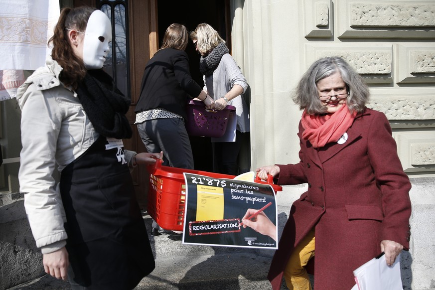 Mitarbeiter der Bundeskanzlei (hinten) nehmen die gesammelten Unterschriften in Waeschekoerben von Elisabeth Joris, Praesidentin des Komitees (vorne rechts), entgegen, bei der Einreichung der Petition ...