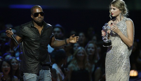 FILE - In this Sept. 13, 2009 file photo, singer Kanye West takes the microphone from singer Taylor Swift as she accepts the &quot;Best Female Video&quot; award during the MTV Video Music Awards in Ne ...