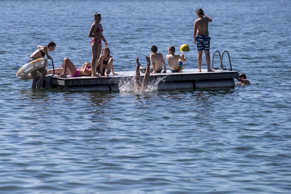 Jugendliche geniessen das sommerliche Wetter auf einem Floss im Seebad in Arth am Mittwoch, 22. Juni 2016. (KEYSTONE/Alexandra Wey)