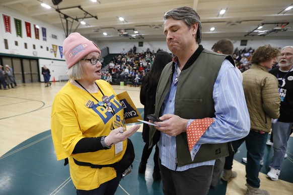 Elizabeth Hendrix, of Des Moines, Iowa, precinct captain for Democratic presidential candidate former South Bend, Ind., Mayor Pete Buttigieg, tries to persuade Tim Gannon, of Des Moines, Iowa, to join ...