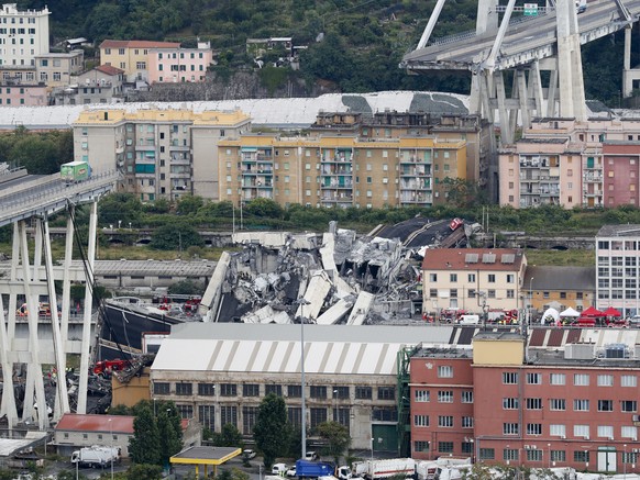 FILE - In the Aug. 14, 2018 file photo, cars are blocked on the Morandi highway bridge after a section of it collapsed, in Genoa, northern Italy. Prosecutors in Genoa on Friday, June 25, 2021, request ...