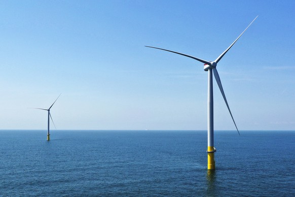FILE - Two of the offshore wind turbines, which have been constructed off the coast of Virginia Beach, Va., are seen, June 29, 2020. Virginia regulators granted a critical approval Thursday, Dec. 15,  ...