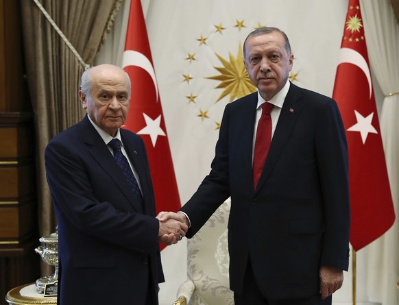 Devlet Bahceli, left, leader of Nationalist Movement Party, or MHP, and the main ally of Turkey&#039;s President Recep Tayyip Erdogan, right, shake hands before a meeting at the presidential palace in ...