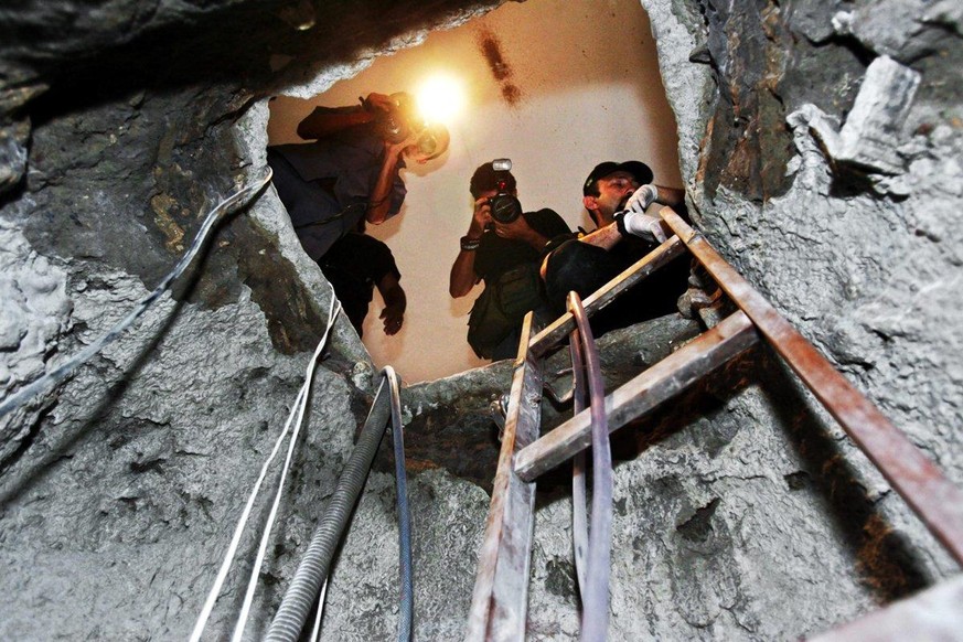 Police and reporters investigating the tunnel that took thieves three months to dig in order to break into Brazilian Central Bank in Fortaleza, Brazil.