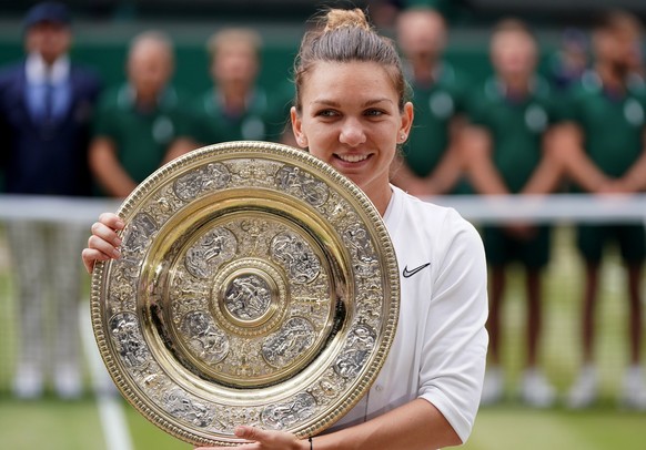 epa07714633 Simona Halep of Romania celebrates with the trophy after winning against Serena Williams of the USA during their final match for the Wimbledon Championships at the All England Lawn Tennis  ...