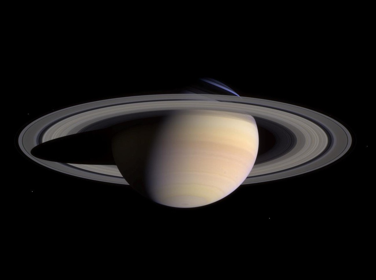 This composite of two images, taken by the Cassini spacecraft May 7, 2004 and released Tuesday June 29, 2004, shows a wide view of Saturn. The white dots in the image are some of Saturn's moons.  ...