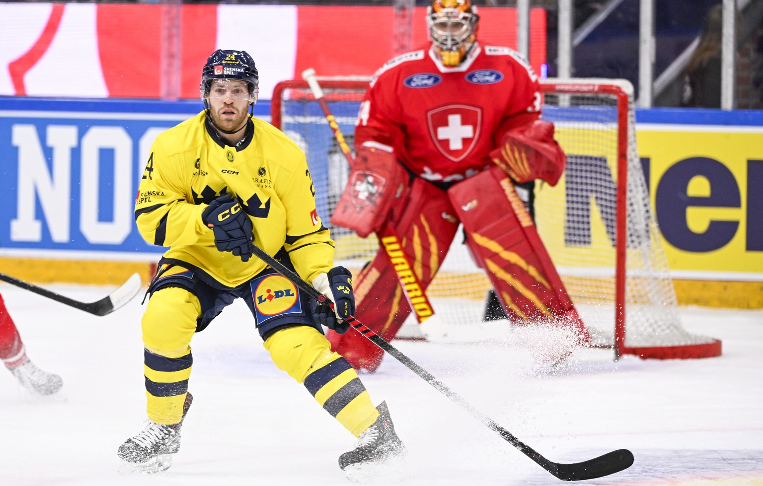 epa11142525 Sweden&#039;s Oscar Lindberg and Switzerland&#039;s goalkeeper Stephane Charlin during the Beijer Hockey Games (Euro Hockey Tour) ice hockey match between Sweden and Switzerland at Lofberg ...