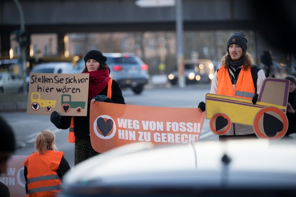 10.01.2024, Berlin: Aktivisten der Klimaschutzgruppe Letzte Generation stehen bei einer Stra