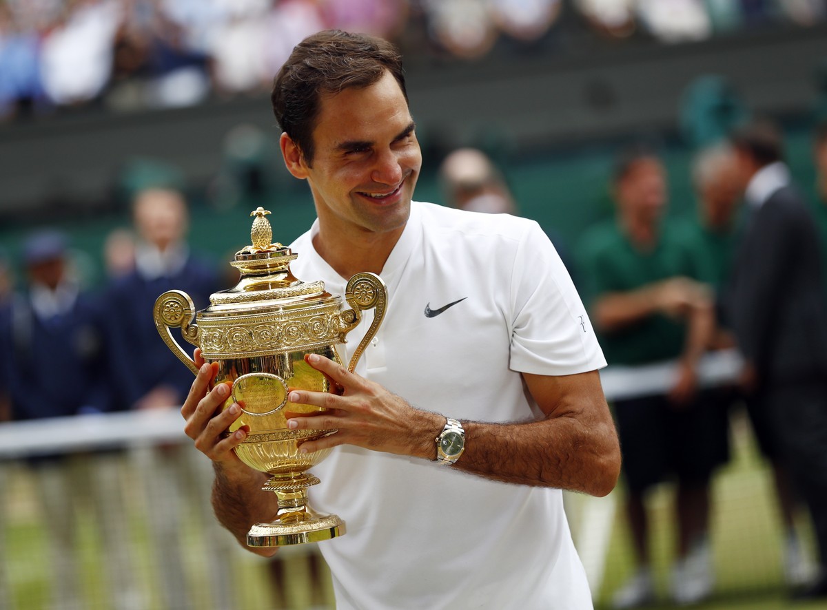 epa10185697 (FILE) - Roger Federer of Switzerland holds the championship trophy following his victory over Marin Cilic of Croatia in the men's final of the Wimbledon Championships at the All Engl ...