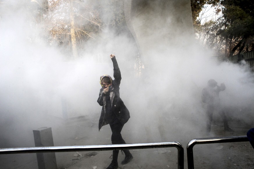 FILE - In this Saturday, Dec. 30, 2017 file photo taken by an individual not employed by the Associated Press and obtained by the AP outside Iran, a university student attends a protest inside Tehran  ...