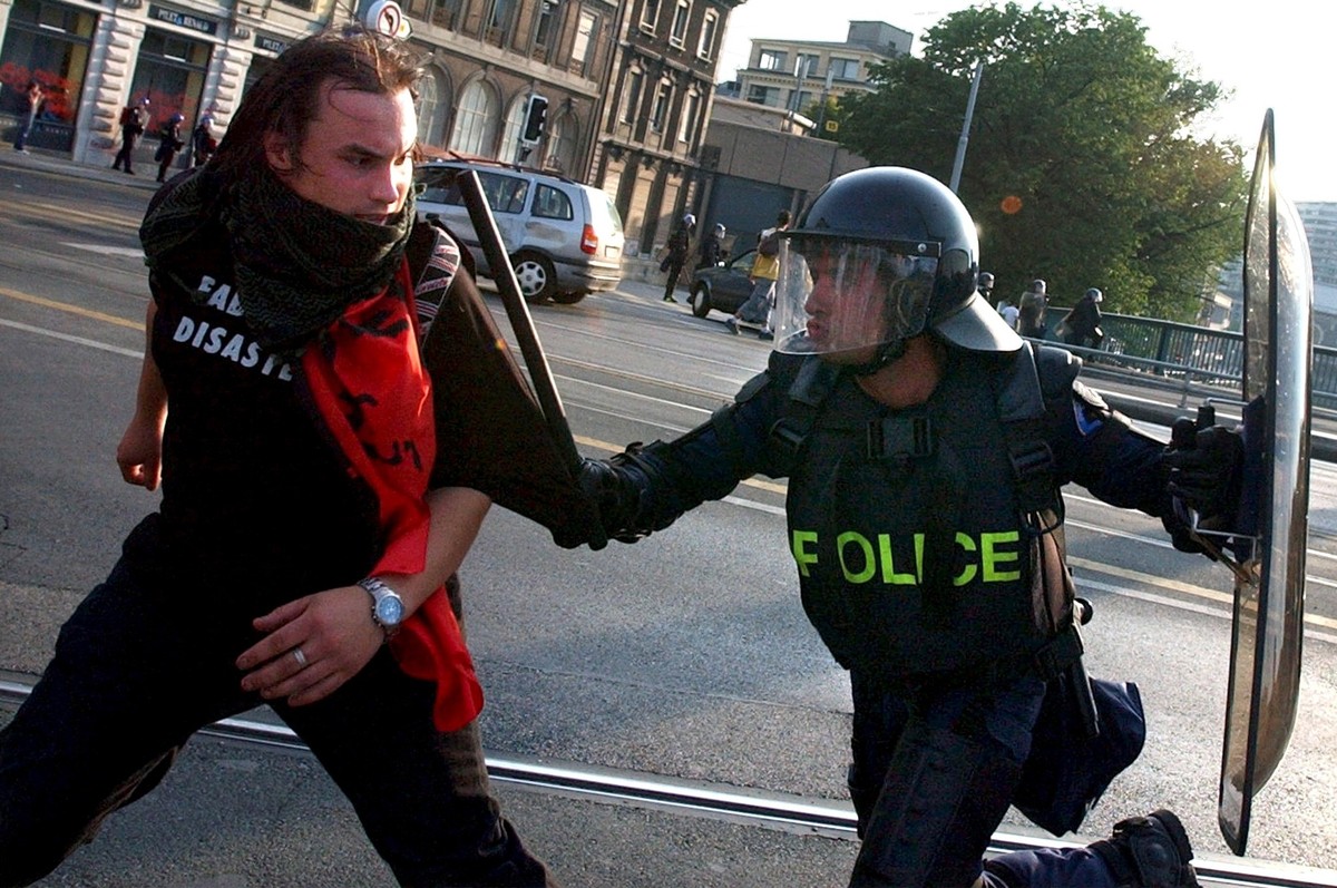 A police officer arrests a rioting demonstrator Sunday, June 1, 2003 in the streets of Geneva, Switzerland. After heavy riots Saturday night and Sunday morning, demonstrators continued to show their d ...