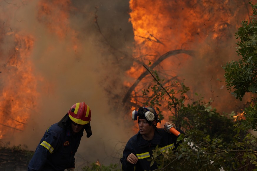Firefighters operate at Ellinika village on Evia island, about 176 kilometers (110 miles) north of Athens, Greece, Monday, Aug. 9, 2021. Firefighters and residents battled a massive forest fire on Gre ...