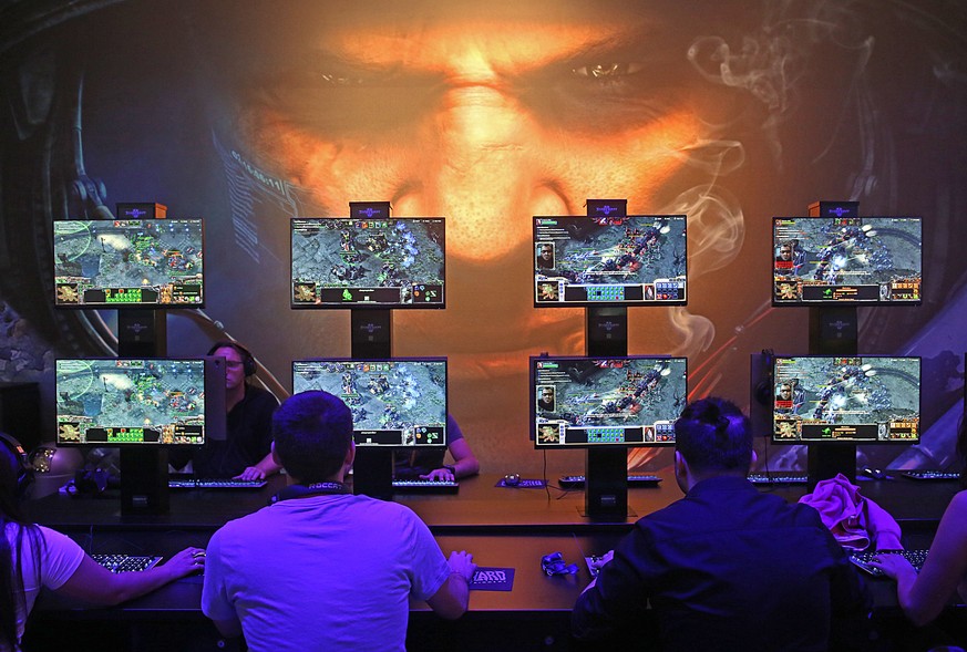 Besucher der Gamescom spielen Starcraft des Entwicklers Blizzard Entertainment. Zum zehnten Mal findet die Computer Spielemesse in Koeln statt. (KEYSTONE/DPA/Oliver Berg)
