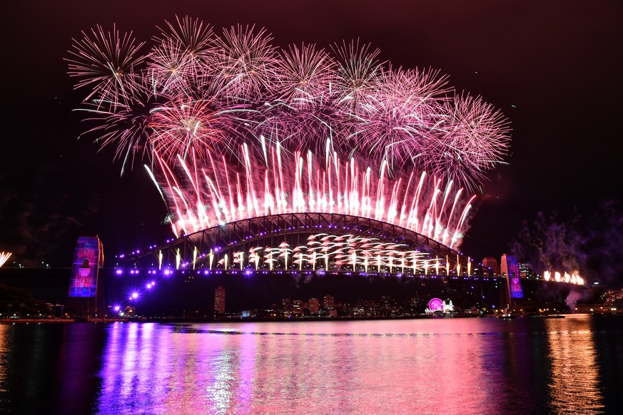 epaselect epa08912472 The midnight fireworks light up Sydney Harbour and the Sydney Harbour Bridge during New Year&#039;s Eve celebrations in Sydney, Australia, 01 Januar 2021. Sydneysiders were asked ...