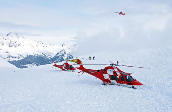 epa04597778 A handout image made available by Swiss Air-Rescue Rega (REGA) of rescue helicopters and rescue workers on duty after an avalanche accident at the Piz Vilan Mountain, eastern Switzerland,  ...