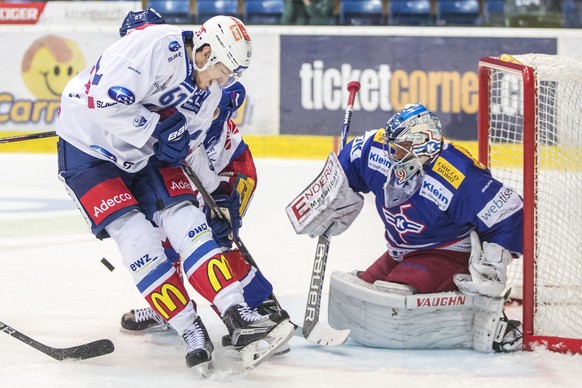 ZSC Lions Stuermer Fabrice Herzog, links, gegen EHC Kloten Torhueter Luca Boltshauser und Verteidiger Dominik Egli, verdeckt, waehrend dem Eishockey-Meisterschaftsspiel der National League zwischen de ...