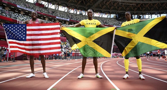 Hansle Parchment, of Jamaica, center, the gold medal winner in the men&#039;s 110-meter hurdles poses with Grant Holloway, of United States, left, silver, and Ronald Levy, of Jamaica, bronze, at the 2 ...