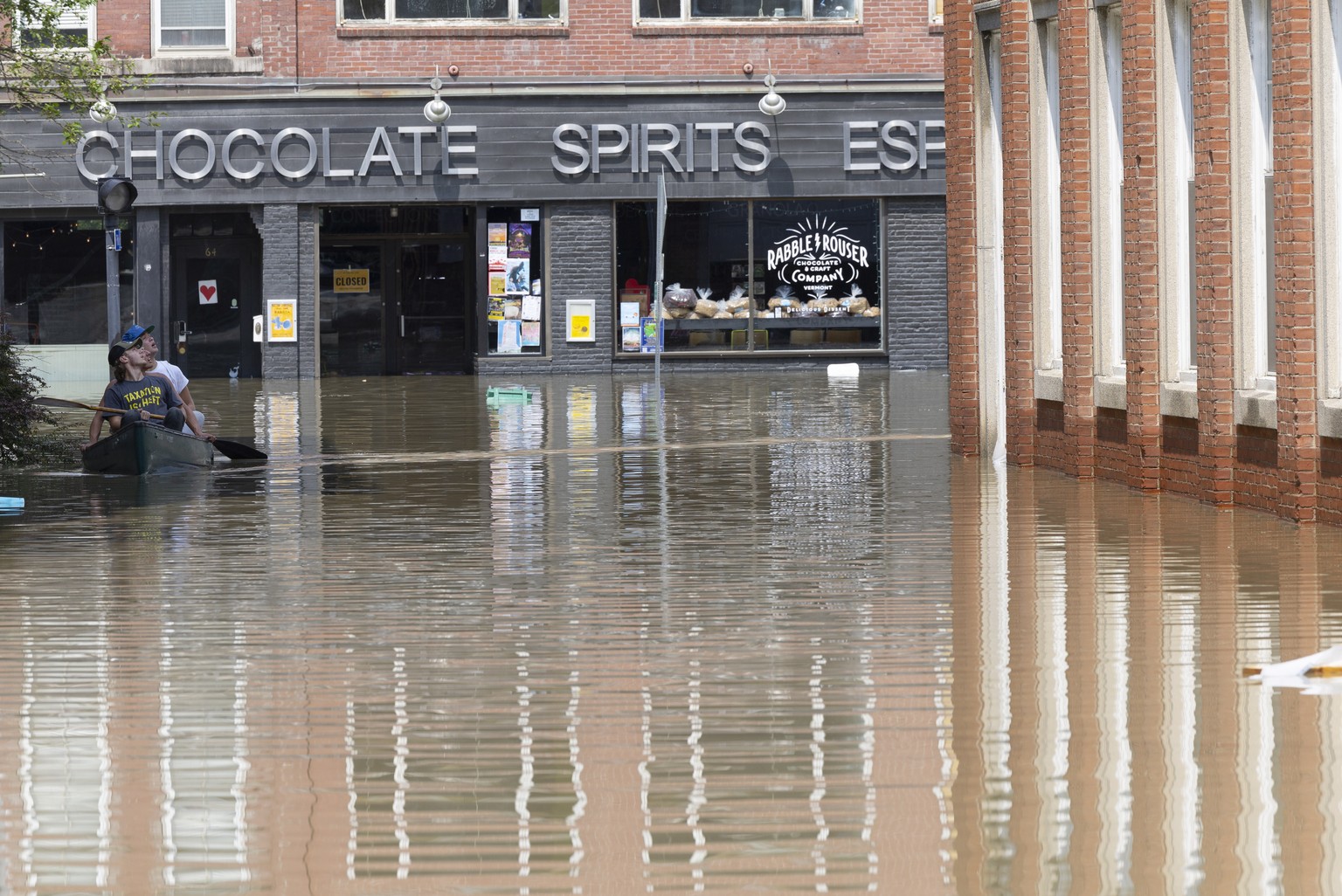 epa10740211 People in a canoe survey flooding as they navigate the streets in Montpelier, Vermont, U.S., July 11, 2023. Heavy rainfall of up to 8 inches (20.3 cm) caused flooding of the Winooski River...