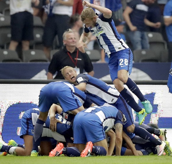 Hertha Berlin&#039;s Fabian Lustenberger jumps on top of his celebrating teammates after Hertha Berlin&#039;s Julian Schieber scored his side&#039;s 2nd goal during the German Bundesliga soccer match  ...