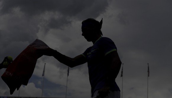 Spain&#039;s Rafael Nadal is silhouetted as he gets a towel while playing Georgia&#039;s Nikoloz Basilashvili during their third round match of the French Open tennis tournament at the Roland Garros s ...