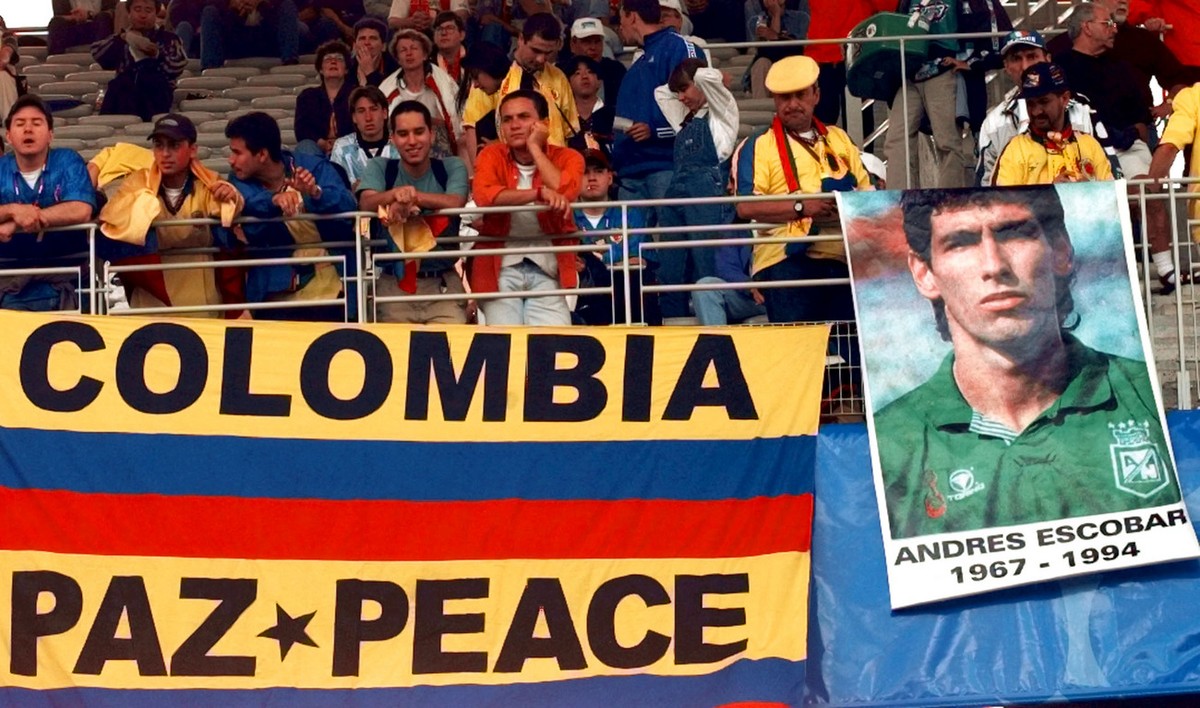 Colombian soccer fans display a flag which reads "Colombia - Peace " and a poster of player Andres Escobar who was killed in Medellin, Colombia, after Colombia was eliminated in the 1994 Wor ...