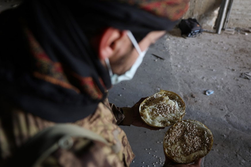 epa11776276 A Syrian rebel fighter shows captagon pills, a synthetic amphetamine-type stimulant, hidden in a fake fruit at a factory for manufacturing captagon pills prior to the fall of the Bashar al ...