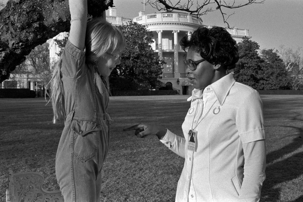 In this image provided by the Jimmy Carter Presidential Library and Museum, Amy Carter hangs from a tree as she speaks with nanny Mary Fitzpatrick on Feb. 23, 1977, on south lawn of the White House in ...
