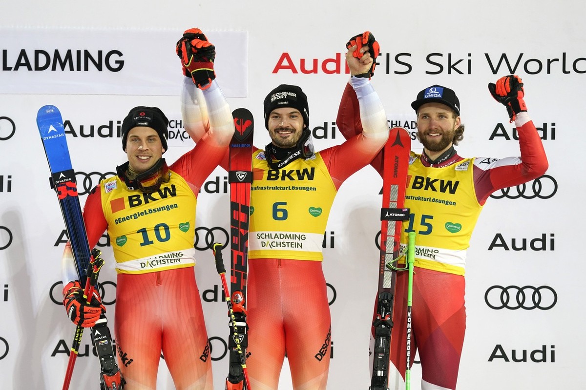 From left, Switzerland's Gino Caviezel, second placed, Switzerland's Loic Meillard, first placed, and, Austria's Marco Schwarz, third placed, celebrate on the podium of an alpine ski, m ...