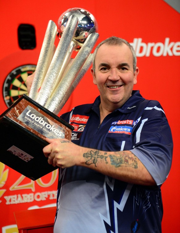 Britain's Phil Taylor lifts the trophy after winning the PDC World Darts Championship final against Michael van Gerwen of the Netherlands in London, Tuesday Jan. 1, 2013. (AP Photo/PA) UNITED KINGDOM  ...
