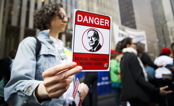 epa05913944 A woman hands out a small card with Bill O&#039;Reilly&#039;s face in front of Fox News Channels&#039; studios during a protest calling on the network to fire O&#039;Reilly for sexual hara ...