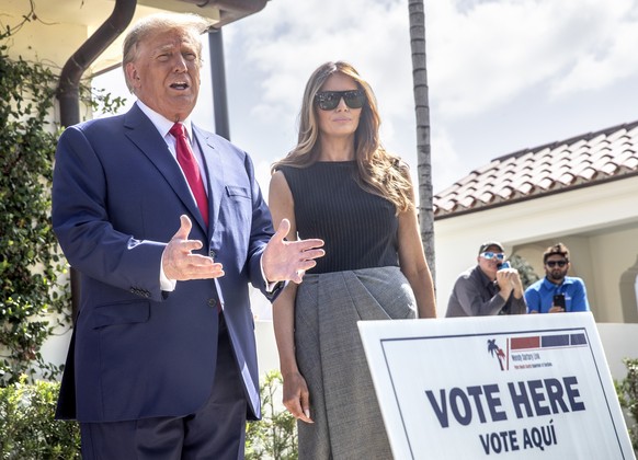 epa10294157 Former US President Donald J. Trump (L) and former First Lady Melania Trump (R), walk out of the electoral precinct after voting in-person at the Morton and Barbara Mandel Recreation Cente ...